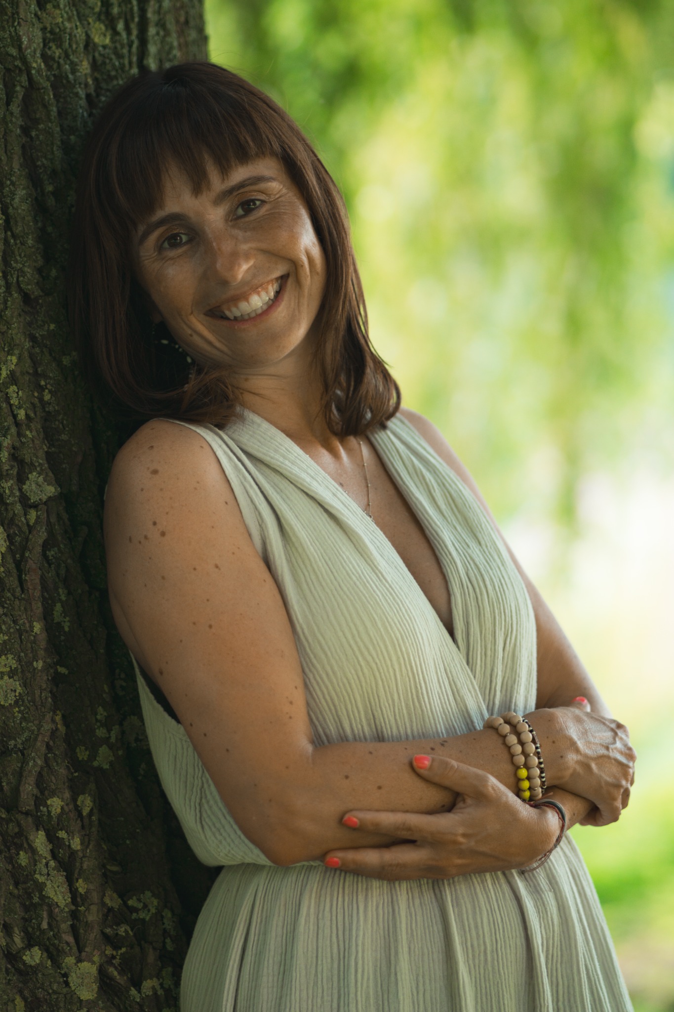 Denise Ulke lehnt lächelnd an einem Baum